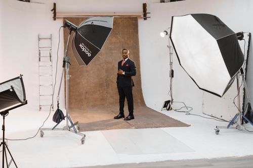 Free Portrait shoot in a modern photo studio with lighting equipment and professional setup. Stock Photo
