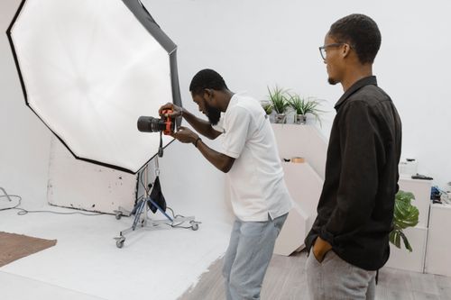 Free Photographer in action during a studio session in Accra, Ghana, capturing professional portraits. Stock Photo