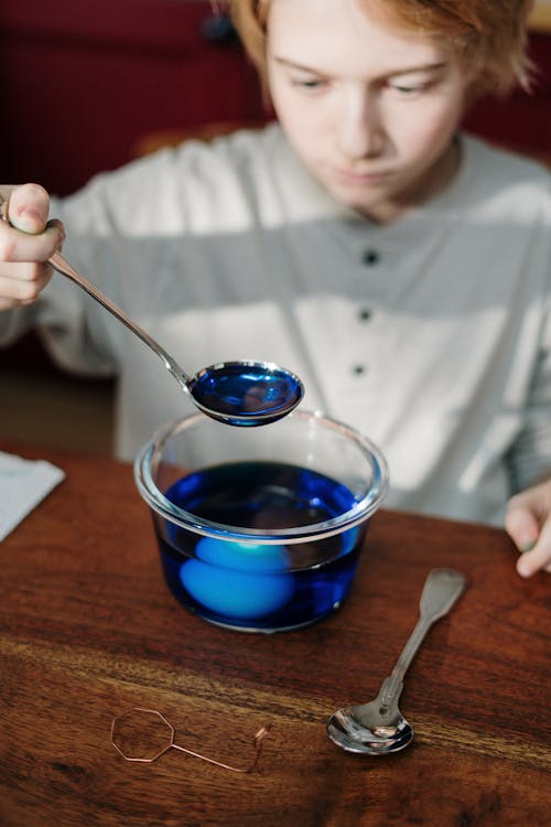 Boy Holding Silver Spoon with Blue Liquid