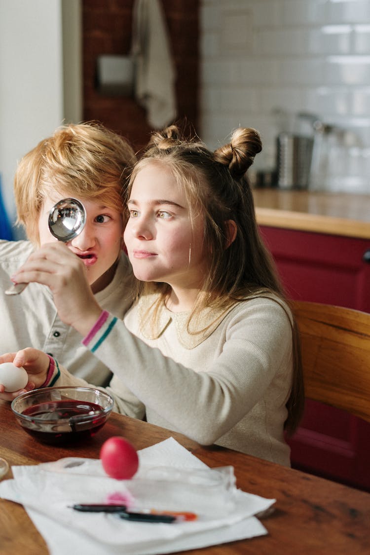 Kids Making Funny Faces On Stainless Spoon