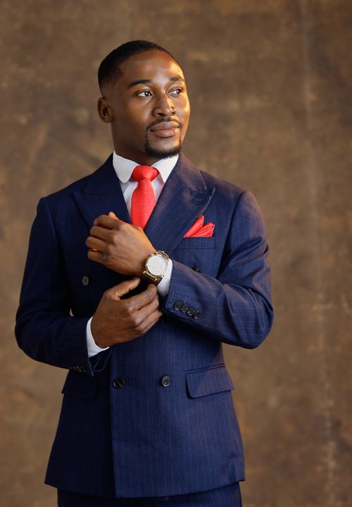 Free Stylish portrait of a man in a sharp blue suit and red tie, exuding confidence. Stock Photo
