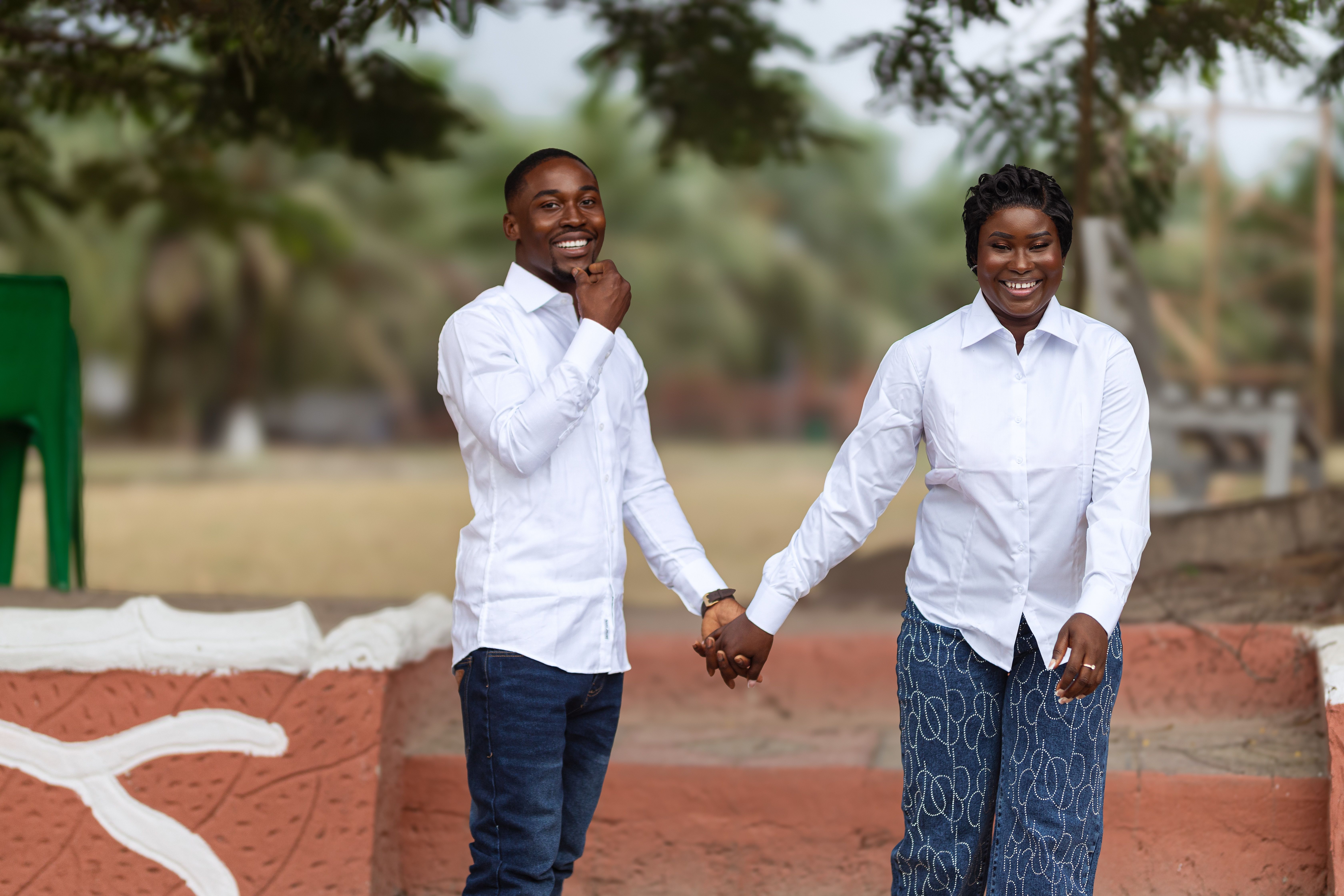 Happy couple posing in a serene Accra park during their prewedding photoshoot.