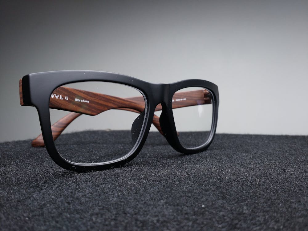 Free Black Framed Eyeglasses on Black Surface Stock Photo