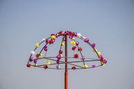 Artistic metal umbrella with vibrant flowers set against a clear blue sky. Perfect for design and creativity themes.
