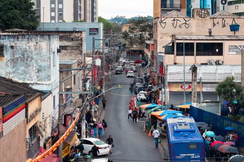 Free Vibrant urban life in São Paulo's bustling street with colorful umbrellas and crowds. Stock Photo