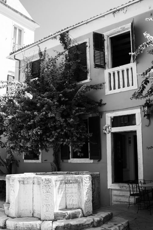 Free Black and white image of a quaint courtyard in Corfu, showcasing historic architecture. Stock Photo