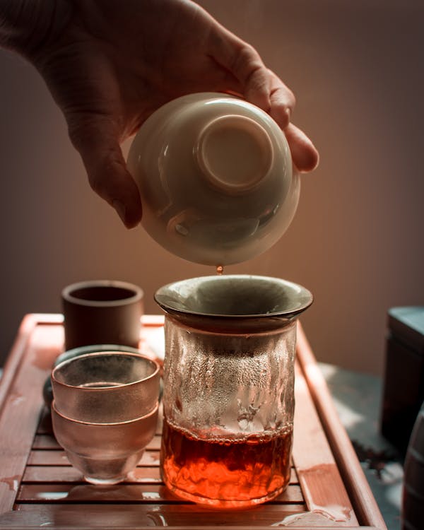 Free Person Pouring Tea on Clear Drinking Glass Stock Photo