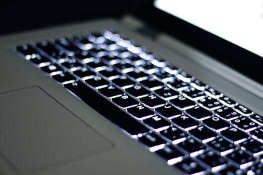 High-quality image of a glowing laptop keyboard with keys in sharp focus, emphasizing technology and modern design.