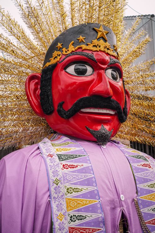 Free Vibrant Ondel-Ondel figure with red face and purple attire during a Jakarta street festival. Stock Photo