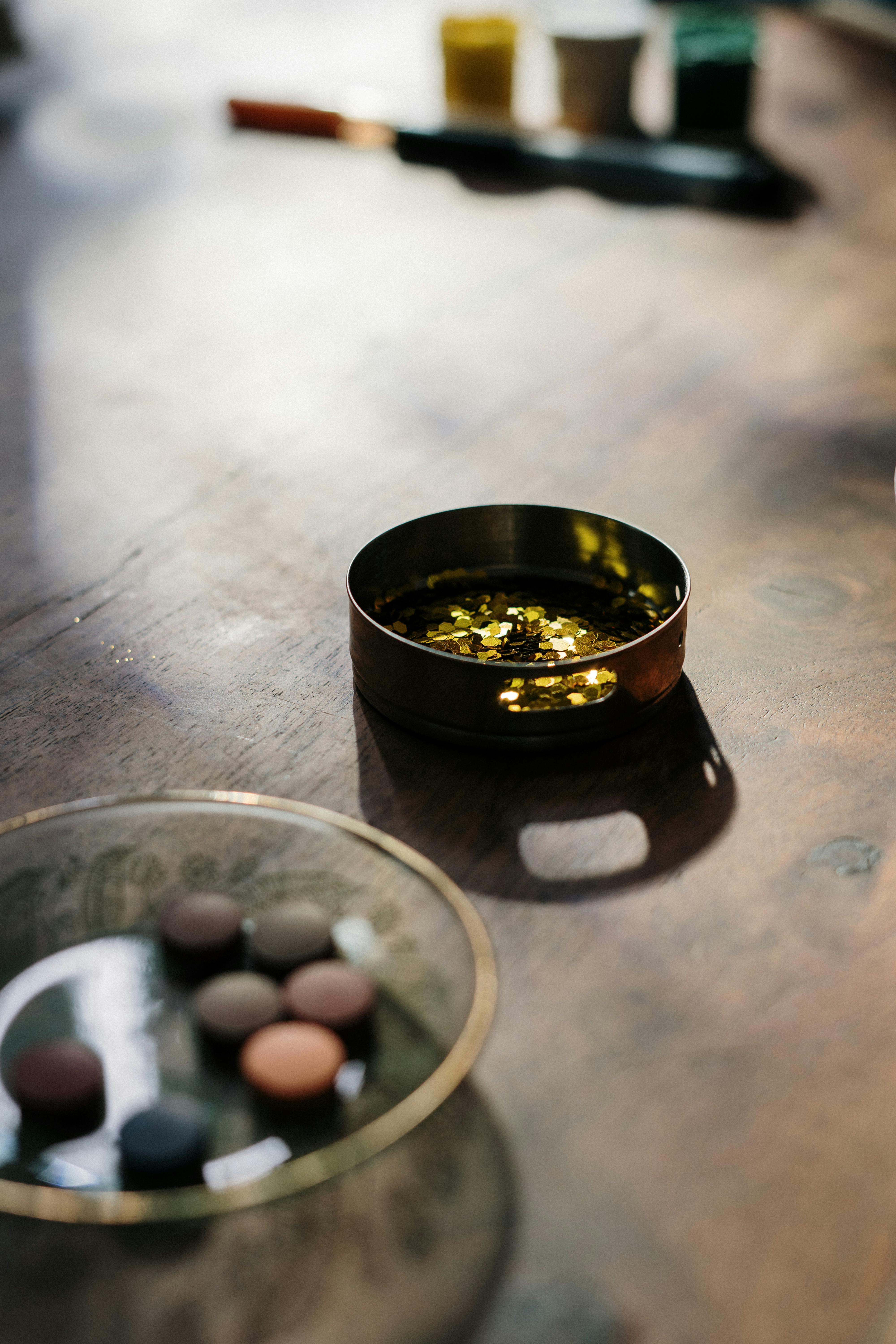 在自然光下，木桌上用金色闪烁和油漆进行艺术设置