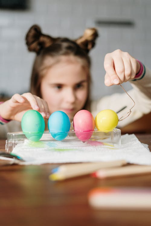 Person Holding Four Colored Eggs