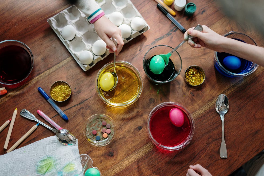 Free People  Holding  Silver Spoons With Colored Eggs Stock Photo