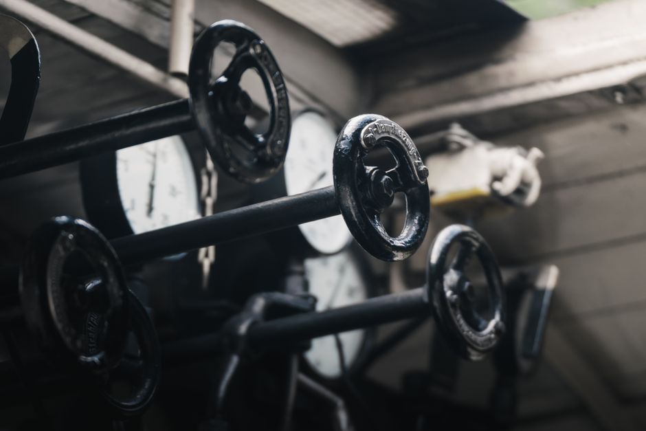 person pulling levers control panel machine