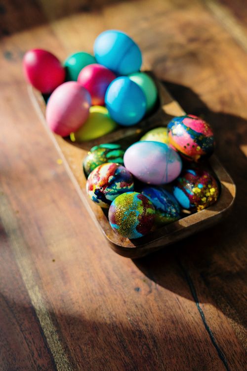 Free Colorful handmade Easter eggs displayed on a wooden tray, celebrating festive decor. Stock Photo