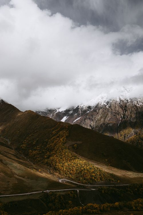 Free A breathtaking view of mountains with overcast skies and lush valleys. Stock Photo
