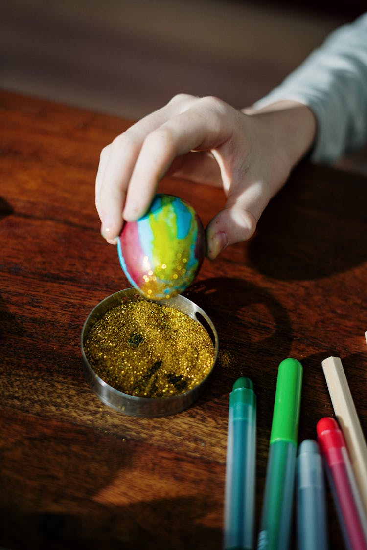 Close-up Photo Of Hand Holding Colored Egg