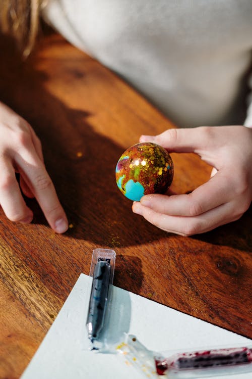 Person Holding Blue and Brown Egg