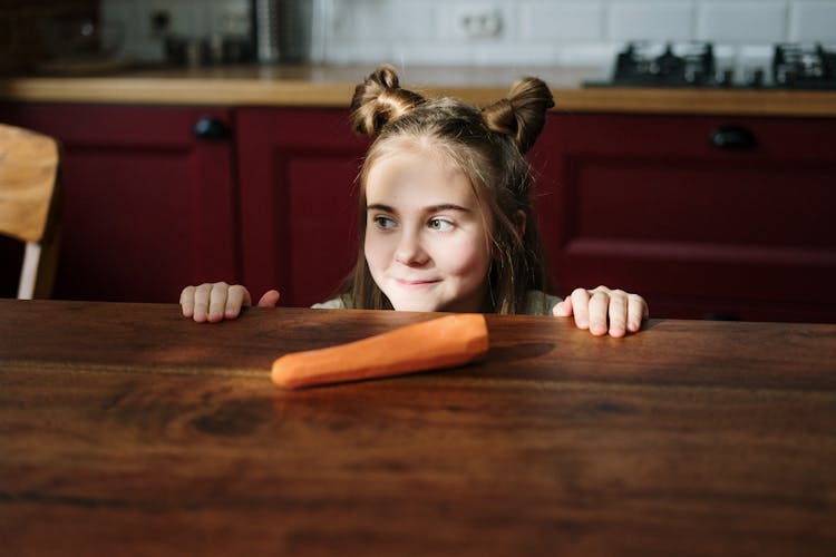 Girl Peeking Over Brown Wooden Table