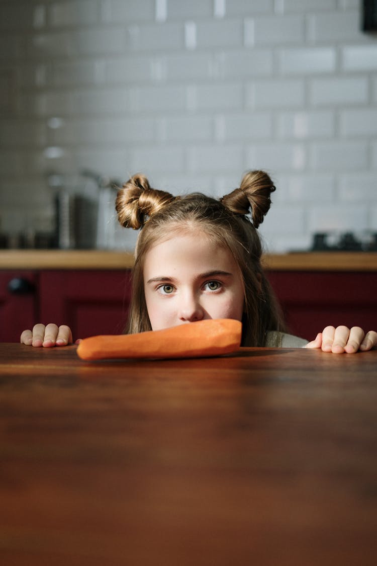 Girl Peeking Over Brown Wooden Table