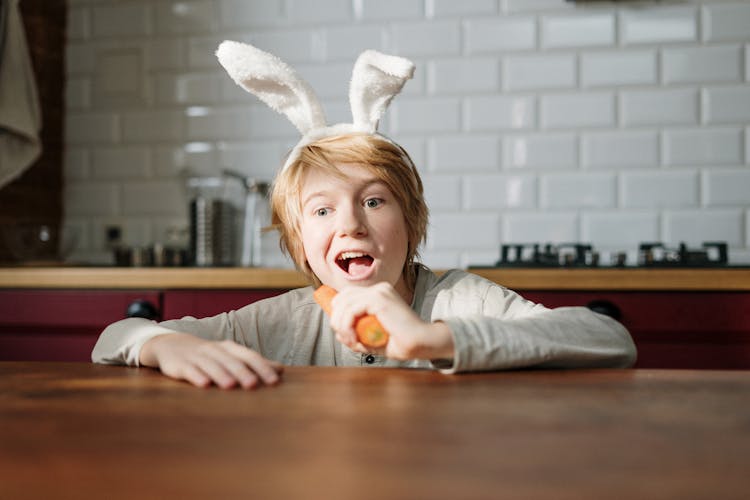 Boy With Bunny Ears Eating Carrot