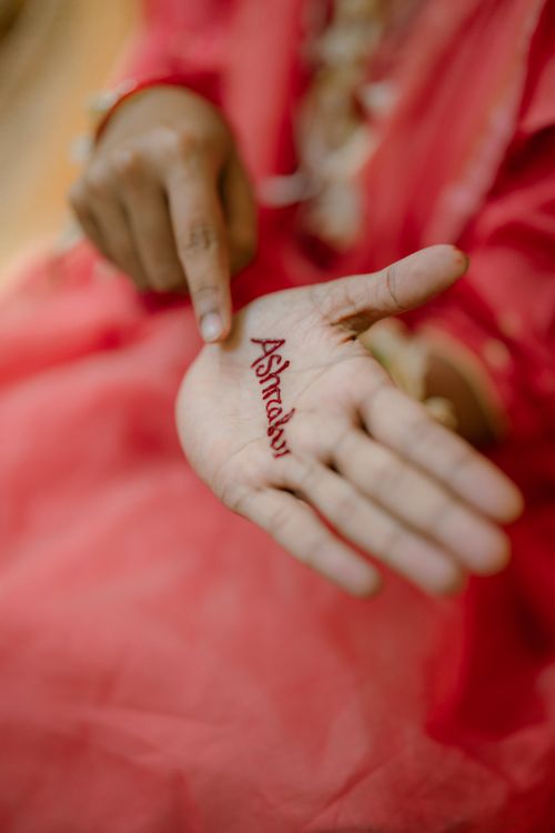Free A close-up of a Bengali bride's hand with "Astraha" written in mehndi. Stock Photo