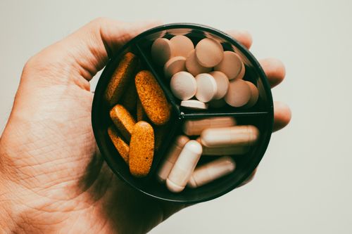 Free Close-up of a hand holding different types of supplements and vitamins. Stock Photo