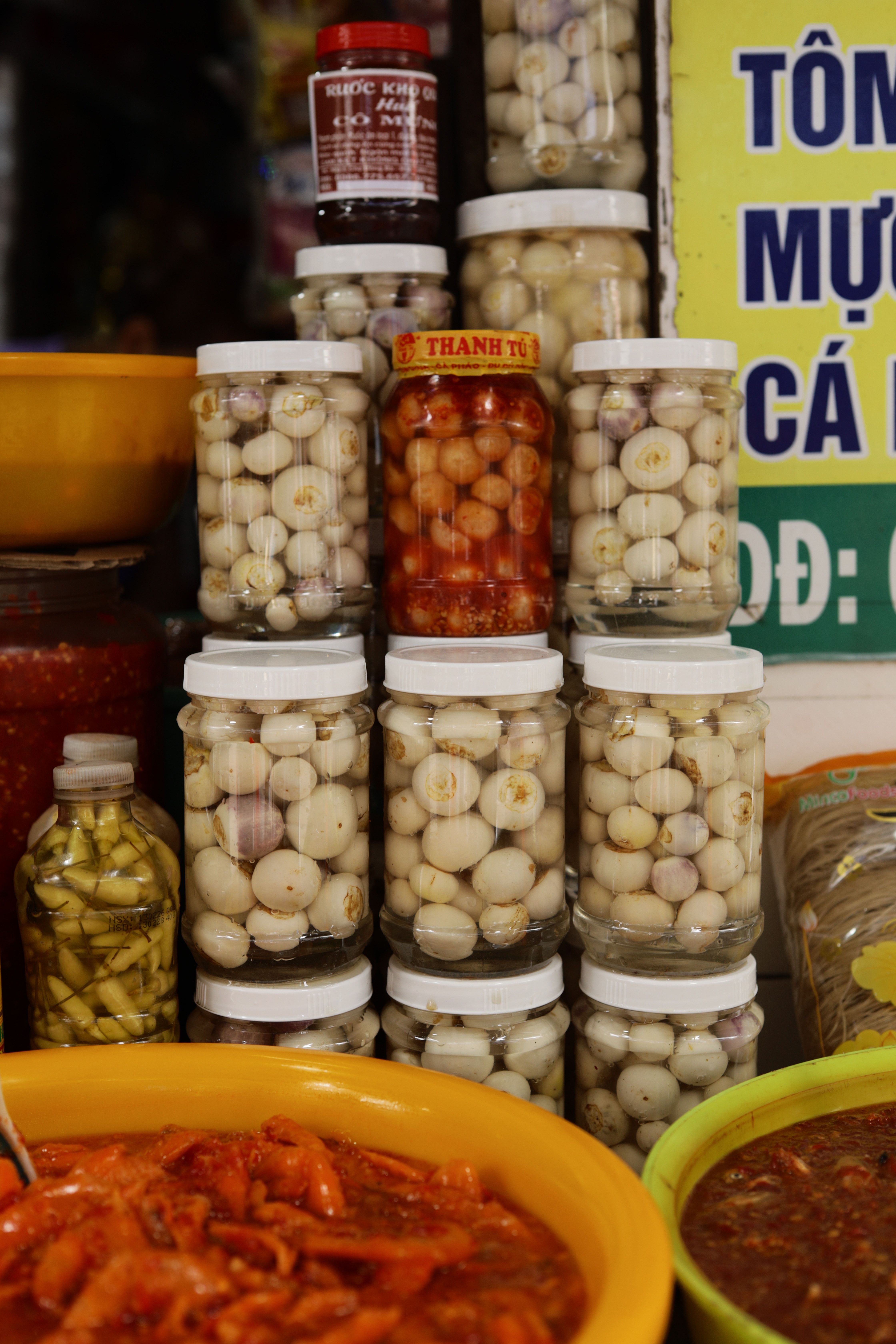 Assorted jars of pickled vegetables displayed at a market in Hue, Vietnam.