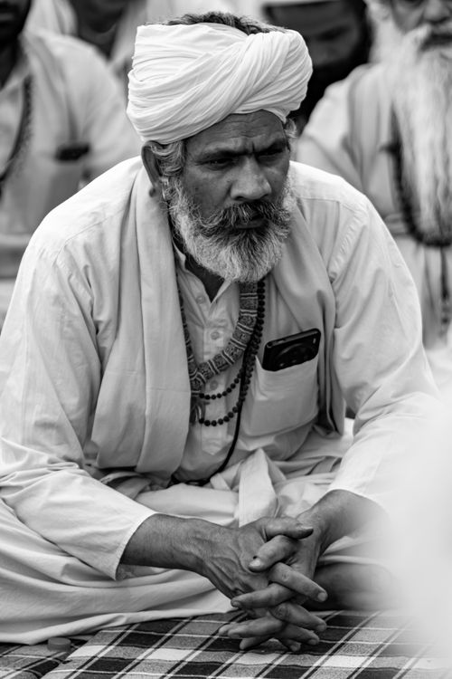 Free Black and white portrait of a senior man in traditional attire, meditating outdoors. Stock Photo