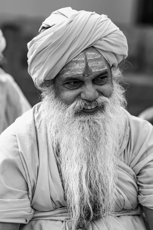 Free Black and white portrait of an elderly man with a turban, featuring a serene smile and traditional attire. Stock Photo