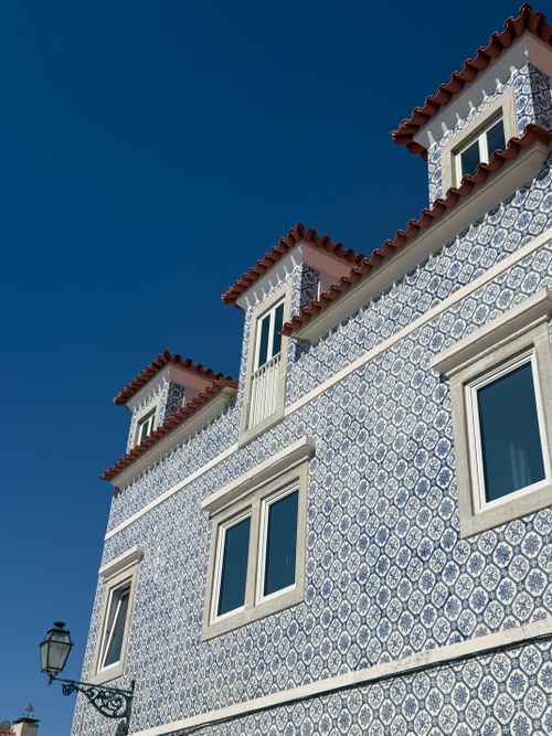 Free Portuguese building with decorative tiles and red roof under clear blue sky in Cascais, Lisbon, Portugal. Stock Photo