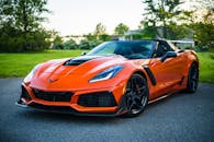 一辆时尚的橙色敞篷跑车优雅地停在风景优美的户外道路上