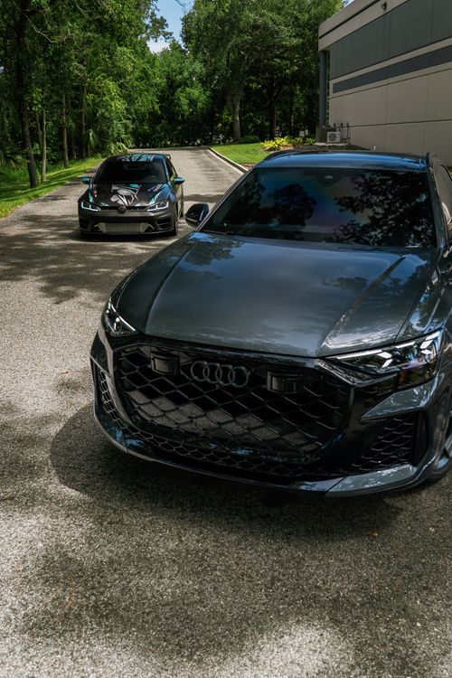 Free Two sleek luxury sedans parked on a scenic tree-lined driveway, showcasing modern design. Stock Photo