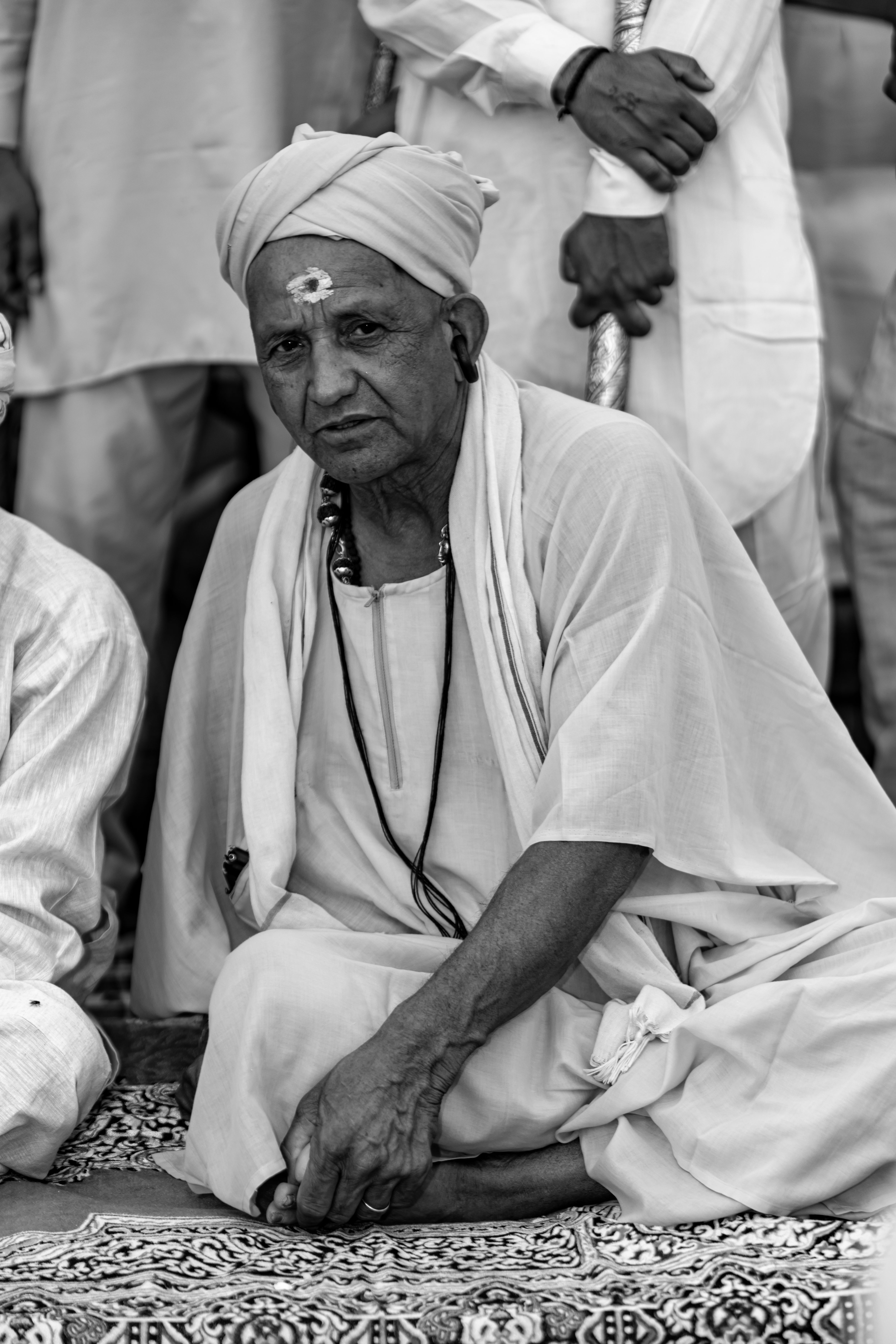A black and white portrait of an elderly Indian man in traditional attire, capturing cultural essence.