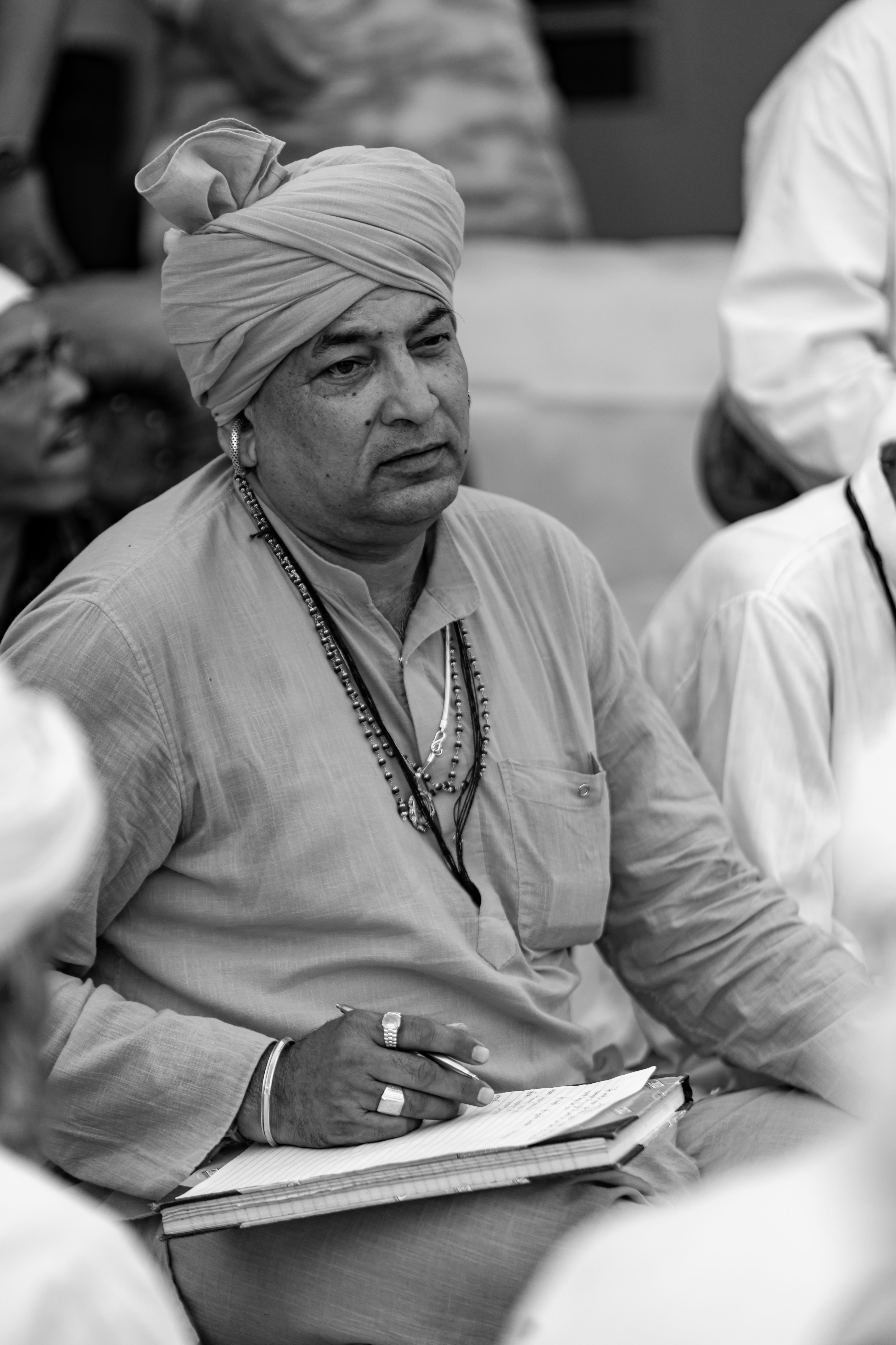 Black and white portrait of a Rajasthani man wearing a turban and kurta, expressing deep thought.