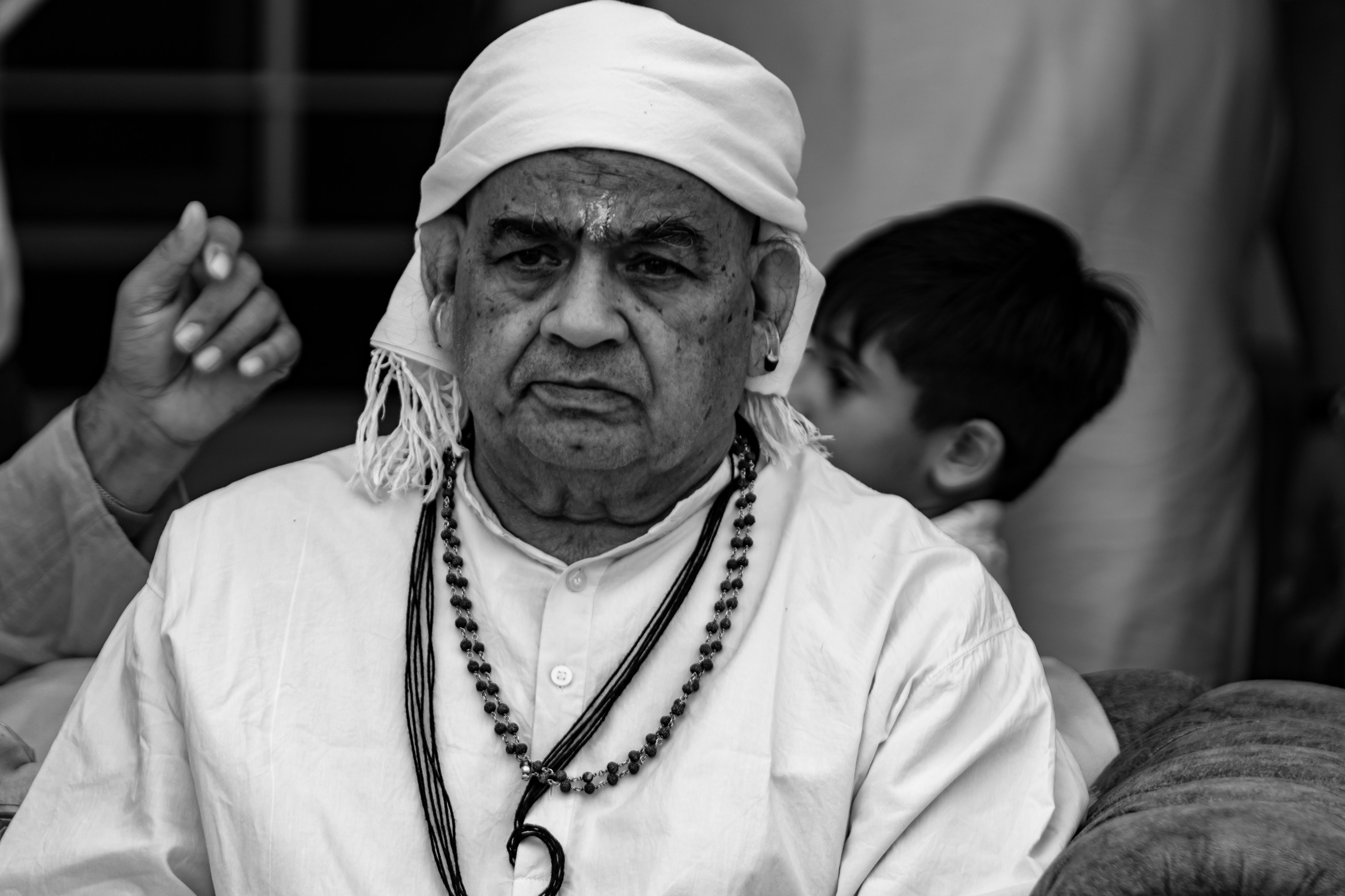 Stark black and white portrait of a senior man wearing traditional Indian attire, exuding wisdom and cultural heritage.