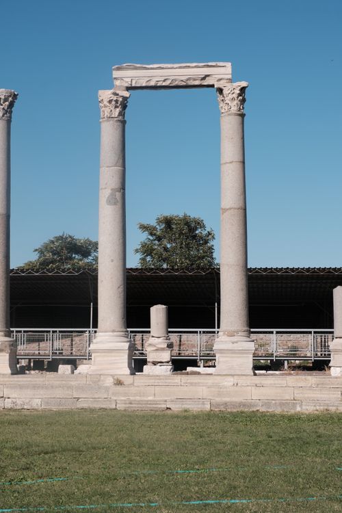Free Stone columns from the Roman era at İzmir Agora, Türkiye, under clear blue skies. Stock Photo