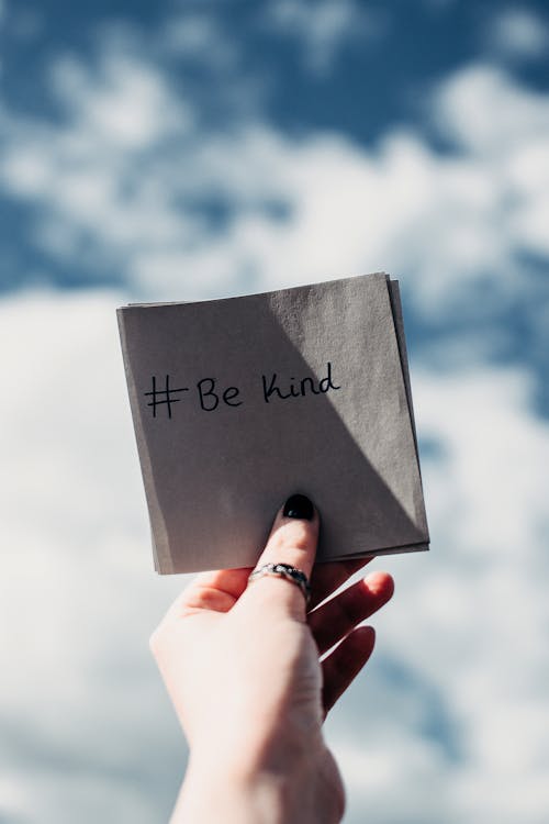 Free Person Holding Note with Be Kind Text Stock Photo