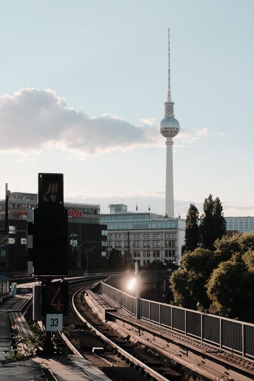 Free Iconic view of Berlin's TV Tower seen from a railway track at sunset. Stock Photo