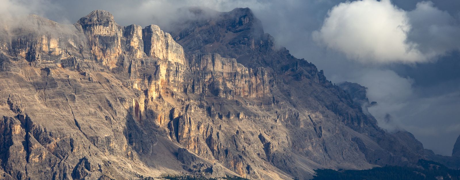 Stunning view of the Dolomites with dramatic clouds and lighting during sunset, capturing the beauty of nature.