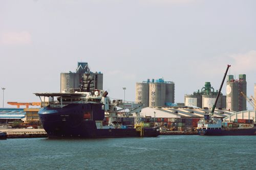 Free Cargo ships docked at a bustling industrial port in Taiwan with containers and cranes. Stock Photo