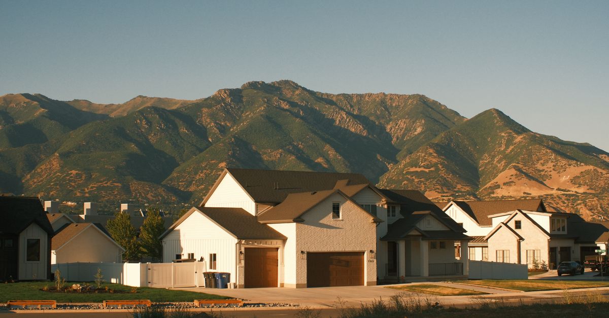 Charming suburban homes against the stunning backdrop of Utah's mountains at sunset. Ideal for real estate and travel insights.