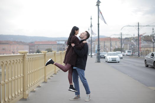 positive young multiracial couple hugging on bridge during walk on street in city
