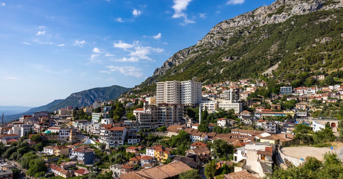 traditional stone village in Albania hillside with castle, golden hour