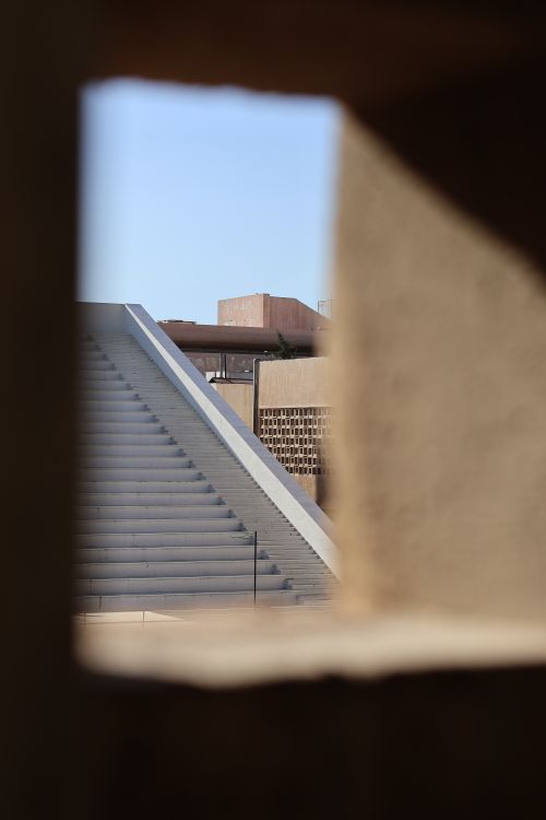 Free A modern architectural staircase framed by angular structures under clear blue skies. Stock Photo
