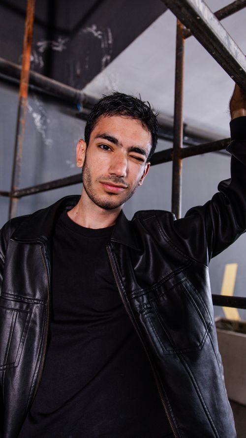 Free Stylish portrait of a young man in a black leather jacket indoors in Istanbul, Turkey. Stock Photo