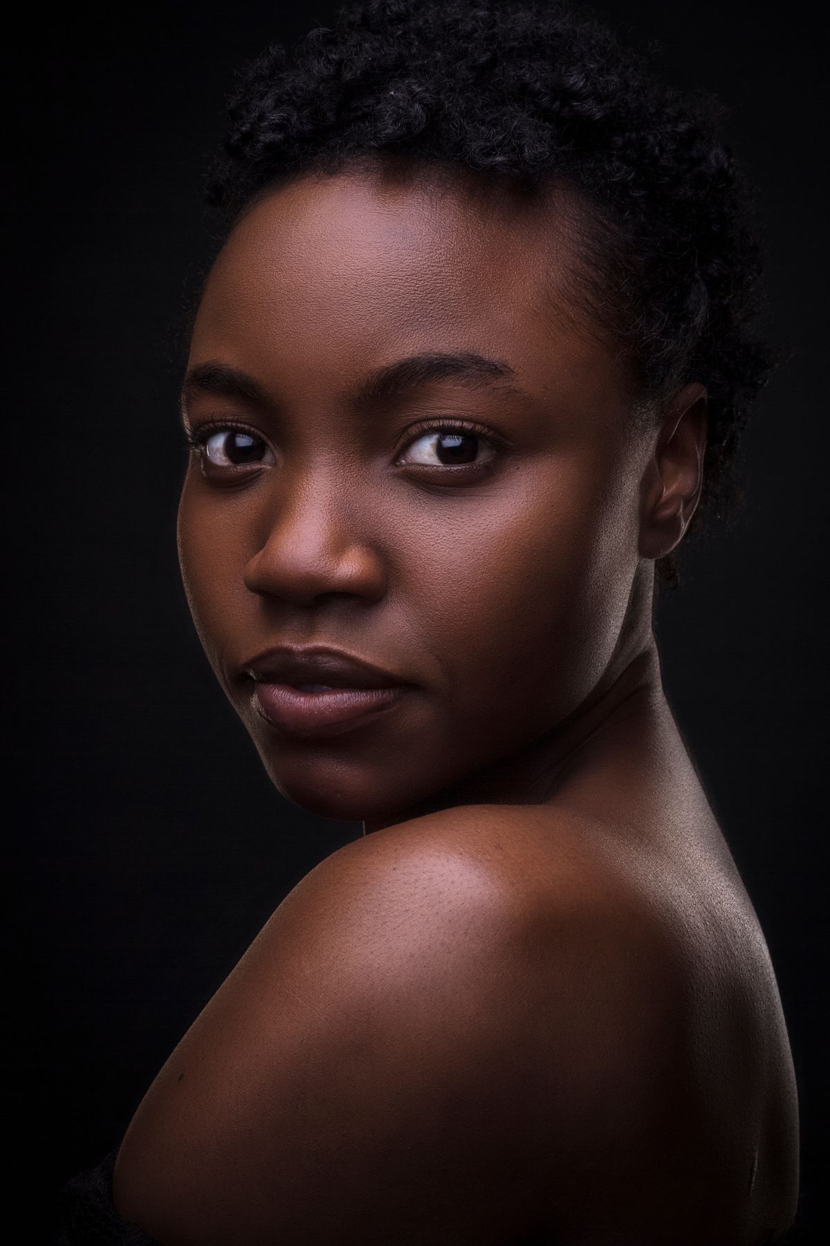 Studio beauty portrait with deep brown eyes on black backdrop