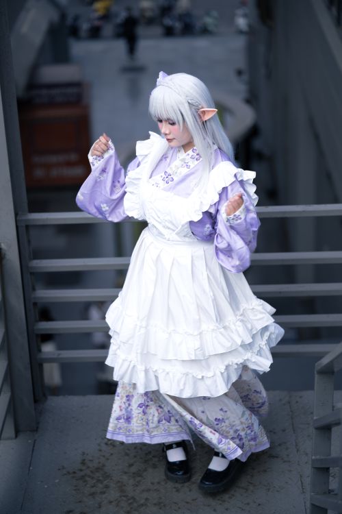 Free A person in fantasy cosplay attire standing outdoors, characterized by a detailed white and purple dress with elf-like features. Stock Photo