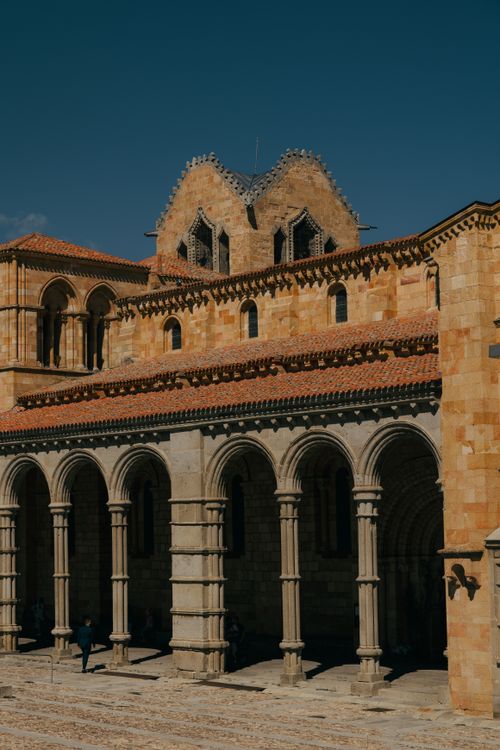Free Sunlit arches of the iconic Romanesque church in Ávila, Spain, capturing architectural beauty. Stock Photo