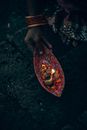 Faceless person with dead mollusk on plate performing ancient rite