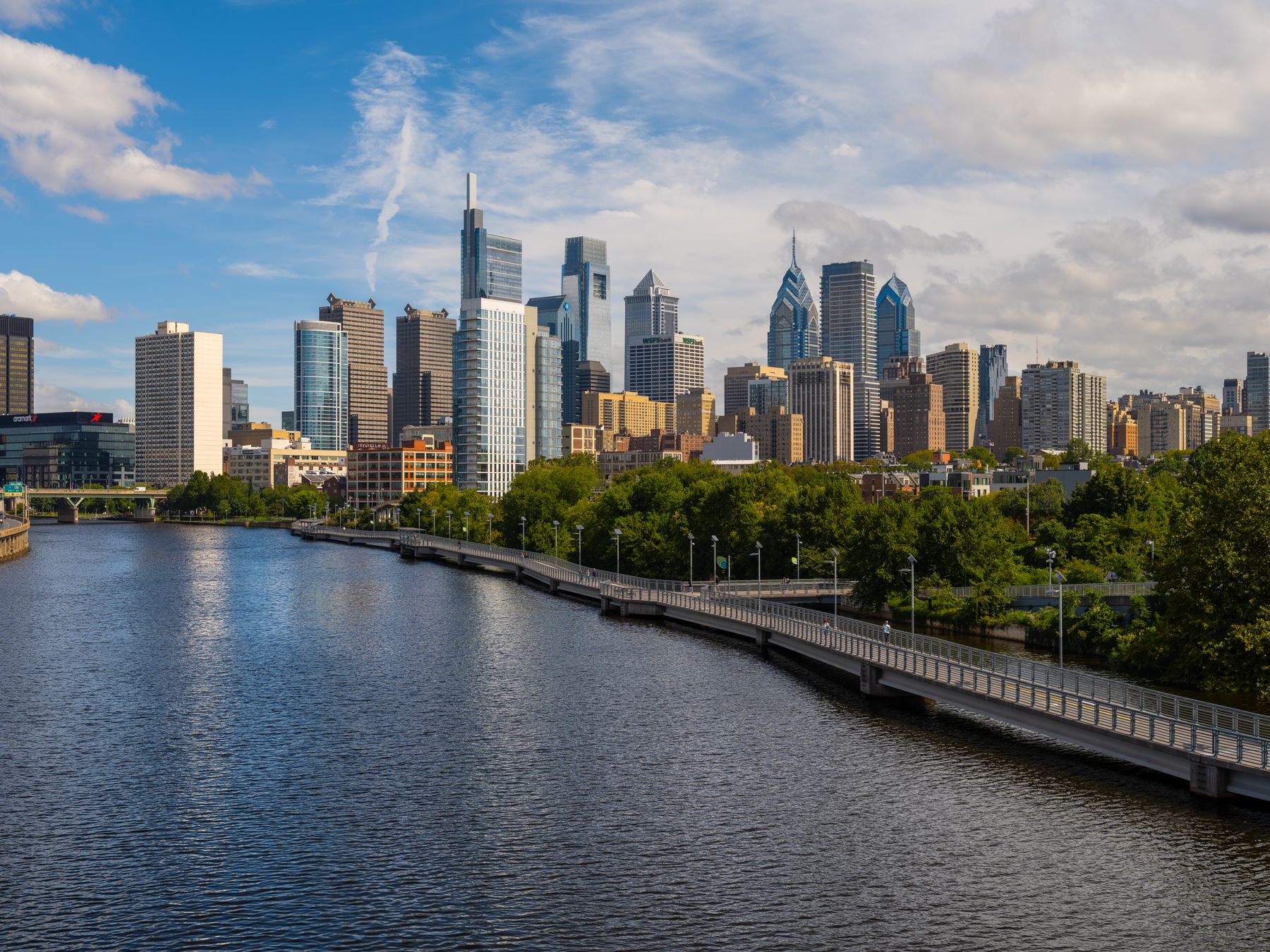 Philadelphia skyline at sunset, presented as a frameless PicPanel mounted on a living room wall